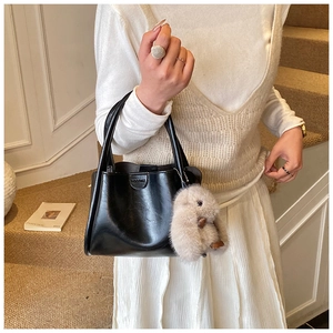 Detail of black matte handbag buckle with a cute plush rabbit pendant charm