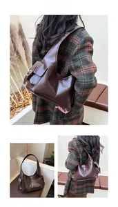 Detail of dark brown oil wax leather shoulder bag with side buckle and vintage retro style