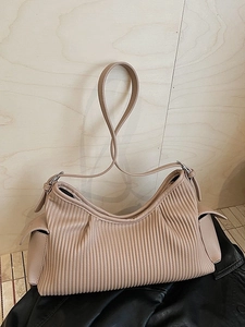 Large beige pleated leather tote bag with side pockets and silver hardware for daily commute