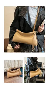 Dettaglio della borsa baguette kaki con texture in pelle arricciata e anello in metallo