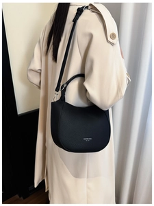 Close-up of black lychee grain leather hobo bag with white logo and silver hardware