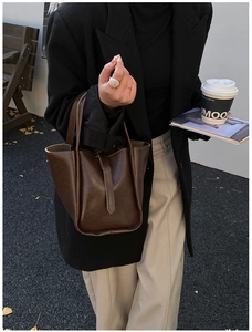 Schicke braune Leder-Eimertasche in einem stilvollen Outdoor-Lifestyle-Streetfashion-Setting