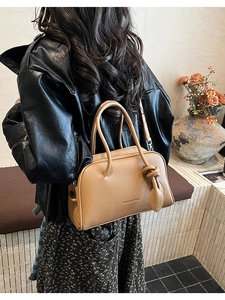 Detailansicht der camel-farbenen Boston-Tasche aus Leder mit Knoten-Anhänger