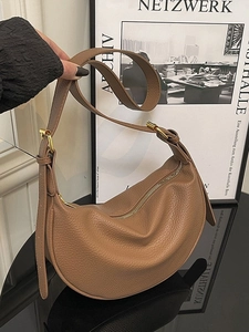 Caramel brown crescent leather shoulder bag with adjustable strap and gold hardware
