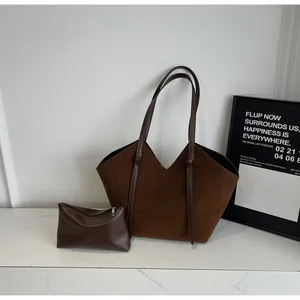 Close-up of brown suede tote bag with V-cut design and matching small clutch set