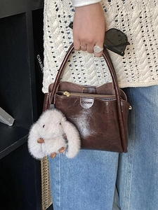 Deep brown glossy leather handbag with cute plush bunny charm and MOCEMO logo detail