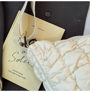 Détail du sac nuage matelassé blanc cassé avec texture nylon et boucle en métal noir