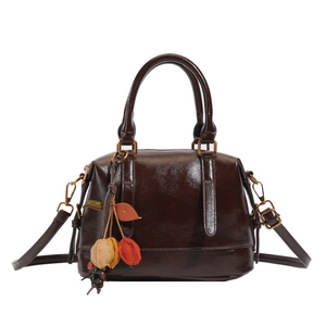 Dark brown leather Boston bag with a vintage glossy finish and decorative fruit charm