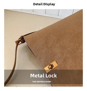 Détail d'un sac en cuir marron avec un fermoir métallique doré et une texture grainée chic