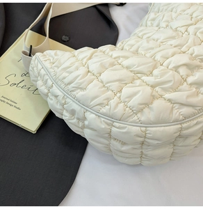 Détail du sac nuage en nylon matelassé blanc avec texture plissée brillante et rembourrage