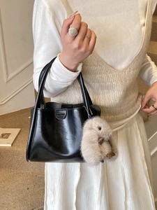 Elegant black leather handbag for women with cute plush rabbit charm and top handles