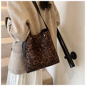 Dettaglio della borsa leopardata con manici in pelle e rivetti metallici decorativi