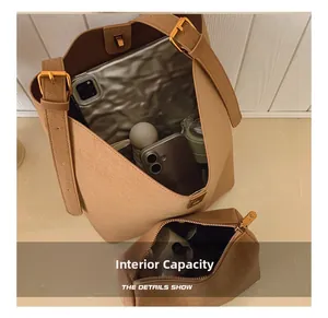 Vue macro de l'intérieur du grand cabas en daim marron et sa pochette assortie