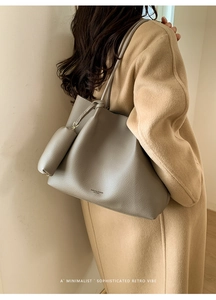Gros plan d'un sac cabas gris grainé avec une petite pochette et des boucles métalliques