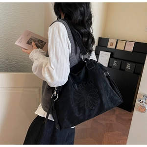 Détail du grand sac cabas noir avec broderie marguerite et anneau métallique chic