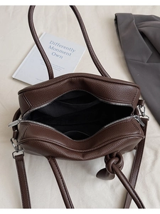 Detail der Innenseite der dunkelbraunen Tasche mit Litschiprägung und schwarzem Futter