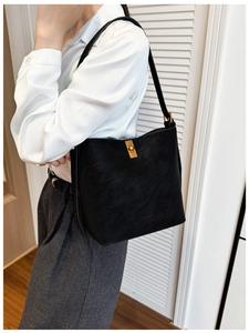 Détail du sac seau noir mat minimaliste avec fermoir tournant en métal doré élégant
