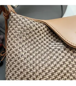 Detail of comfortable woven fabric and premium leather craftsmanship on a crossbody bag