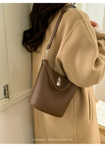 Détail du sac seau marron grainé avec fermoir rotatif argenté porté par un mannequin