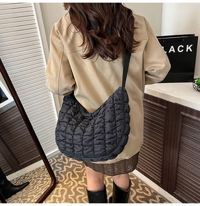 Détail de la texture matelassée du sac nuage noir et tissu en nylon sur le mannequin