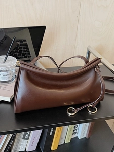Borsa a baguette classica in pelle testa di moro con anello dorato su una scrivania