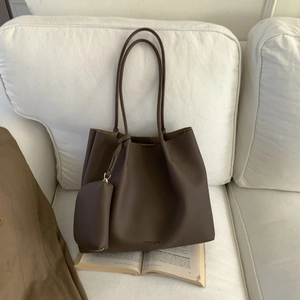 Détail du cabas en cuir marron foncé avec texture grainée et mini pochette assortie