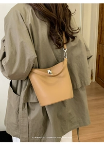 Vue détaillée d'un sac seau minimaliste montrant la texture du cuir grainé et les finitions