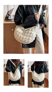 Vue détaillée du sac croissant blanc matelassé montrant la texture en nylon doux