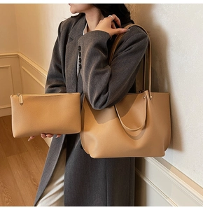 Detail of the large khaki tote bag and matching zipper clutch in textured lychee leather
