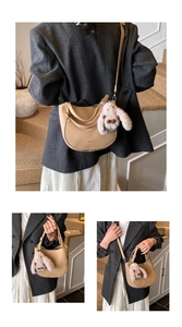 Detail of beige half-moon tote bag with rabbit pendant and sleek leather finish