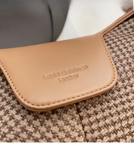 Detail of Louie Daiximan suede leather bag with brown tweed fabric texture and logo