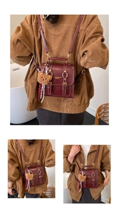 Détail du sac à dos bordeaux en similicuir avec charm ours peluche et boucles dorées