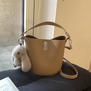 Détail du sac seau camel en cuir grainé avec fermoir argenté et breloque lapin en peluche
