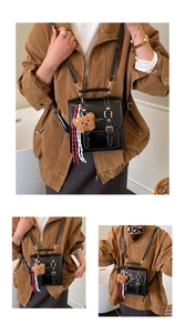 Détail du sac à dos rétro en cuir noir avec boucles doubles et breloque ours peluche