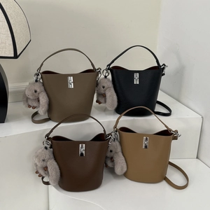 Sacs seau en cuir grainé de quatre couleurs avec breloques lapin sur supports blancs