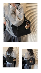 Close-up of black matte tote bag with white contrast stitching and bear charm