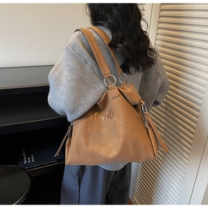 Détail d'un sac cabas marron avec broderie marguerite et lettrage Malodi sur cuir mat