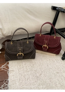Retro shoulder bags in burgundy and grey with gold metal buckle on white faux fur carpet