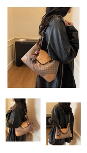 Detail of faux suede shoulder bag with woven texture, leather trim and bear charm accessory