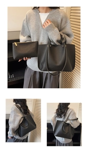 Detail of black pebbled leather tote bag with matching zippered pouch and slim shoulder straps