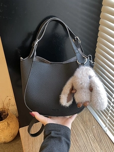 Retro black lychee leather bucket bag with plush rabbit charm and crossbody strap