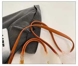 Détail de la bandoulière réglable et des finitions dorées sur le sac à main bicolore