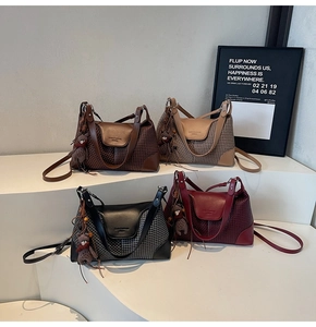 Detail view of four suede handbags in burgundy, black, brown and beige with bear charm