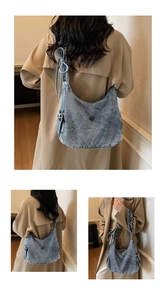 Detailed close-up of blue denim crescent bag with drawstring sides and bow strap