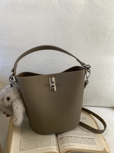 Sac seau en cuir grainé kaki avec fermoir rotatif argenté et charm de lapin en peluche