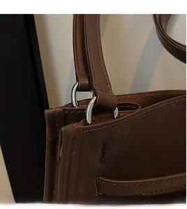 Detail of vintage brown leather bag showing secure silver D-ring and precise stitching