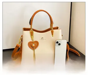 Détail du sac à bandoulière bicolore avec breloque cœur et logo kangourou en métal