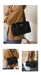Detail of black matte retro underarm bag with white contrast stitching and oval logo