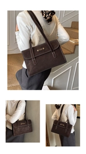 Close-up of retro brown shoulder bag with white stitching and golden logo plate