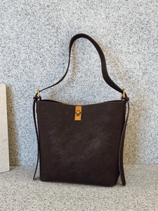 Sac seau minimaliste en cuir marron foncé avec fermoir doré et grande capacité de rangement